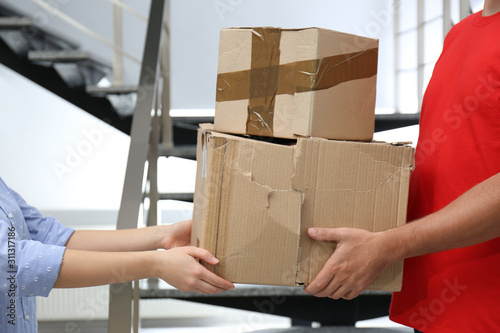 Courier giving damaged cardboard boxes to client indoors, closeup. Poor quality delivery service © New Africa