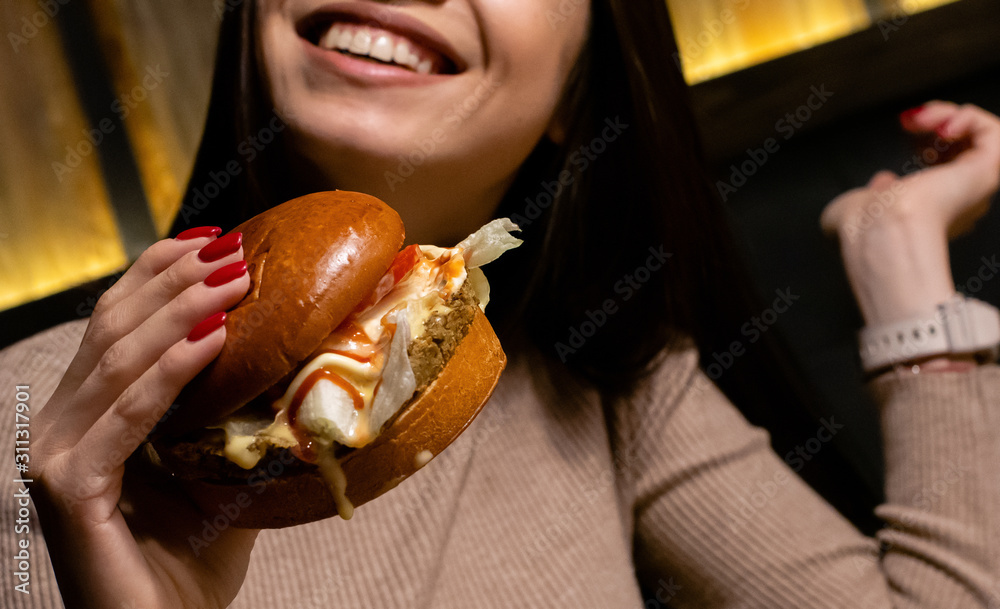 Hands holding fresh delicious burgers close up Hands holding fresh delicious burgers close up