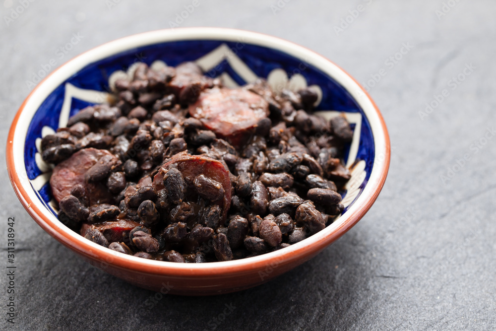 black beans with smoked sausages in ceramic dish black beans with smoked sausages in ceramic dish