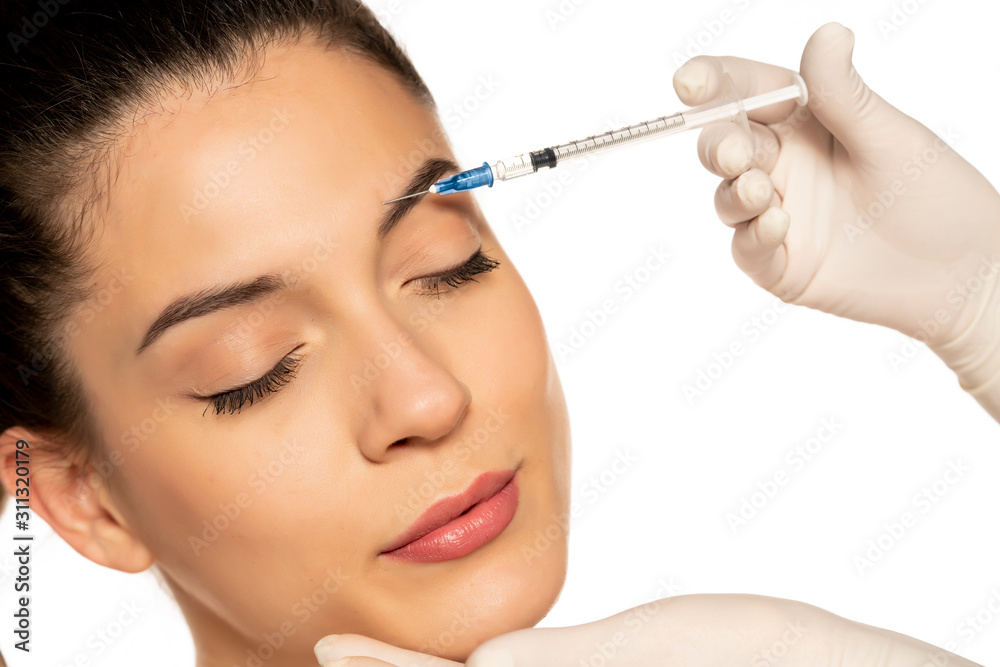 Portrait of a young beautiful woman on a botox injection procedure on white background