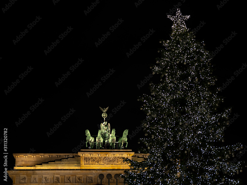 Illuminated Neoclassical Brandenburg Gate (Brandenburger Tor) and Christmas Tree in the year 2019 as viewed from the Pariser Platz, Berlin, Germany