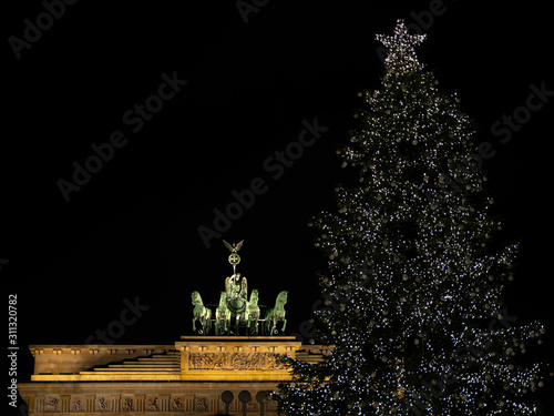 Obraz na płótnie Illuminated Neoclassical Brandenburg Gate (Brandenburger Tor) and Christmas Tree in the year 2019 as viewed from the Pariser Platz, Berlin, Germany w salonie