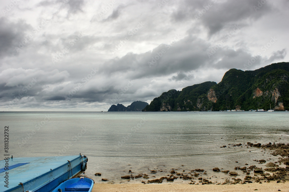 Cape covered with greenery on the Islands of Phi Phi. Low tide on the beach of Tonsai.