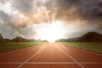 Running track with green grass and mountain view