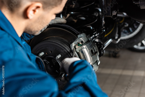 selective focus of mechanic adjusting brake caliper with screw driver