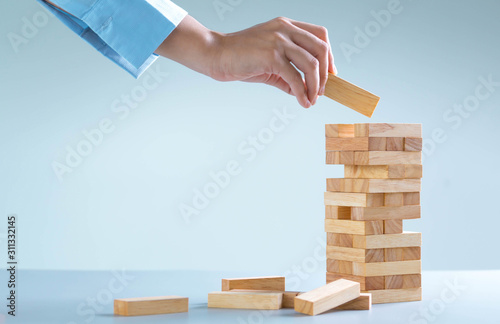 planning, risk and strategy in business, businessman gambling placing wooden block on a tower © SizeSquare's