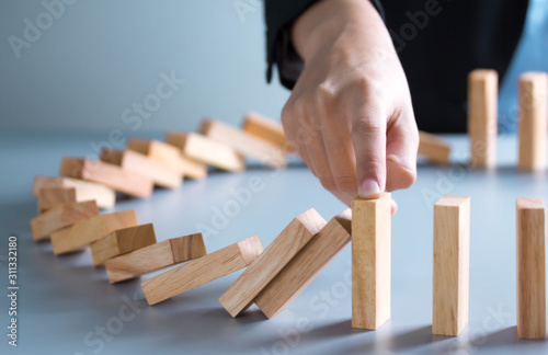 Tablou pe pânză businessman hand stop dominoes continuous toppled or risk with copyspace
