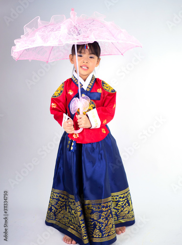 Asian little girl wearing a Korean Traditional Hanbok dress in white background[The pattern on the fabric is Fu Lu Shou refers to the three Chinese deities]