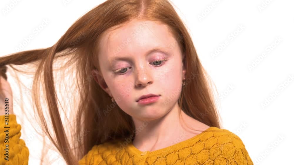 Portrait shot of a school girl twisting her gorgeous foxy hair and smiling. Young cute model posing for camera Portrait shot of a school girl twisting her gorgeous foxy hair and smiling. Young cute model posing for camera
