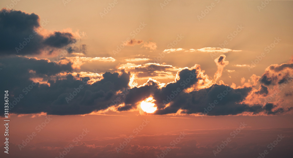 Panoramic view of red sky with sun in clouds at sunset time. Natural background