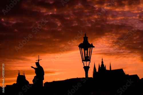 Old Prague at sunset. Silhouette of Charles Bridge in Prague against the background of an orange sunset sky. Post card.