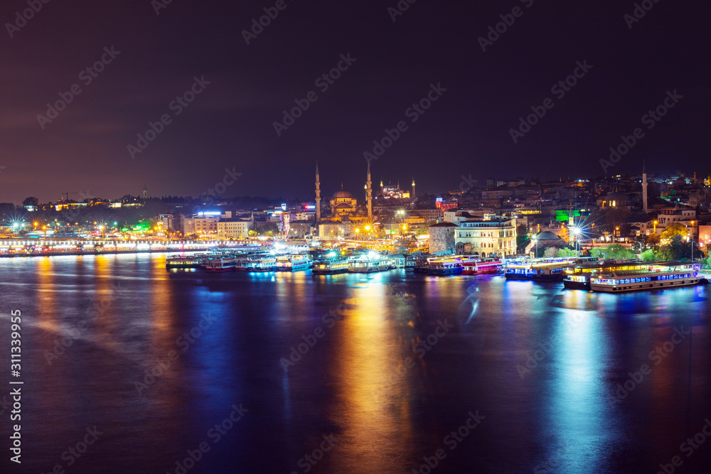 Night view of illuminated Galata bridge with Suleymaniye Camii, Istanbul, Turkey
