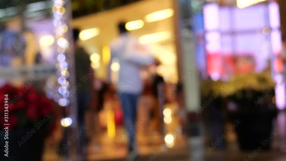 People walk through entrance of shopping mall People walk through entrance of shopping mall