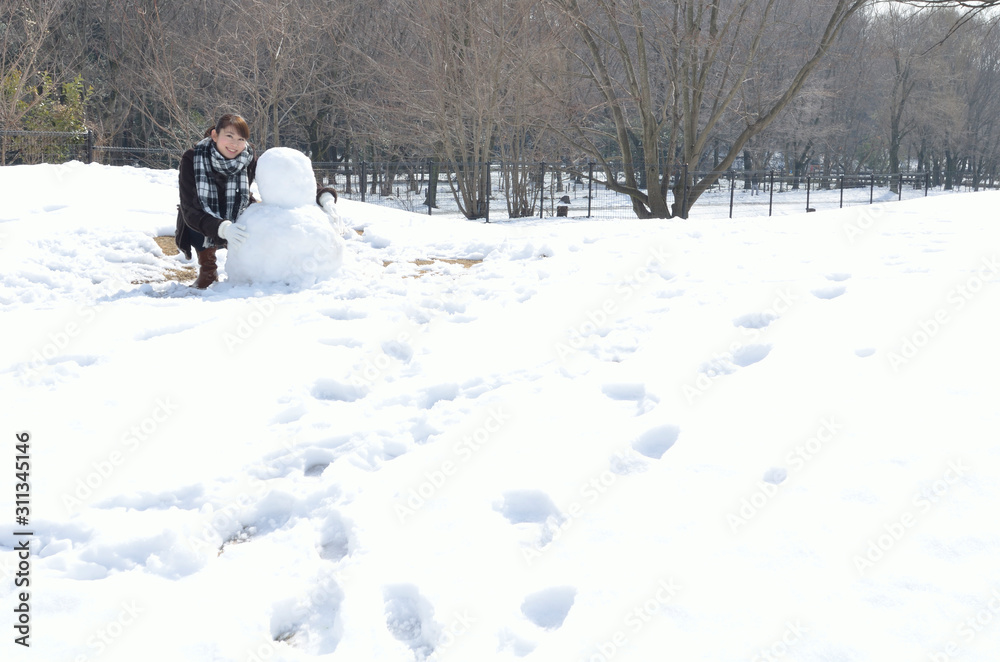 雪だるまを作る若い女性
