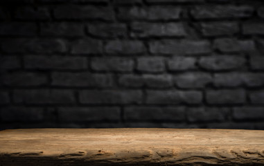 Wood table in front of rustic brick wall blur background with empty copy space on the table for product display mockup. Retro design montage presentation.