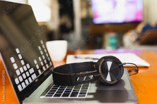 Headphones on laptop keyboard in blur background.