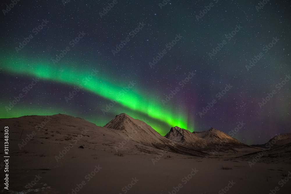 Dramatic polar lights, Aurora borealis over the mountains in the North of Europe - Tromso, Norway.long shutter speed.