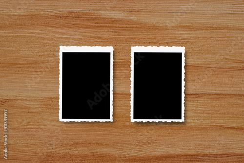 Top view of blank photo frames on wooden table background.