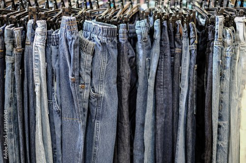 Row of hanged blue jeans pants in shop