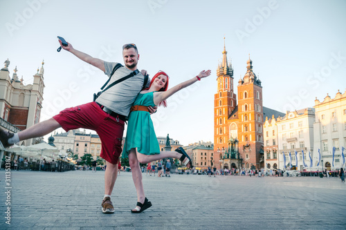 Happy couple dance in love on the street near the Wavel castle in Krakow  Poland. Tourism travel concept  copy space. Man and woman  summer sunset.