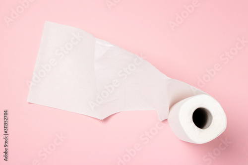 Roll of paper towels on a pink background. Concept is 100 natural product, delicate and soft. Flat lay, top view. Banner