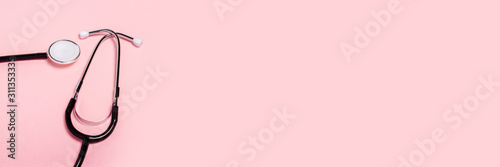 Medical stethoscope on a pink background. Concept of health care, medicine, virus, epidemic, high quality, the best in the world. Banner. Flat lay, top view