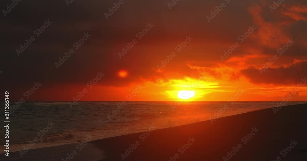 Tropical beach. Dark orange clouds day to night sky reflected in big waves crushing coast. Beautiful dramatic sunset sky. Red purple orange blue pink sunset cloud background. Ocean surfer lifestyle. Tropical beach. Dark orange clouds day to night sky reflected in big waves crushing coast. Beautiful dramatic sunset sky. Red purple orange blue pink sunset cloud background. Ocean surfer lifestyle.