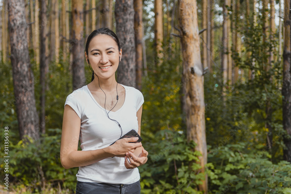 portrait of happy woman with headphones on fitness running workout Wellness concept. athletic girl running in the Park and doing Jogging exercises portrait of happy woman with headphones on fitness running workout Wellness concept. athletic girl running in the Park and doing Jogging exercises