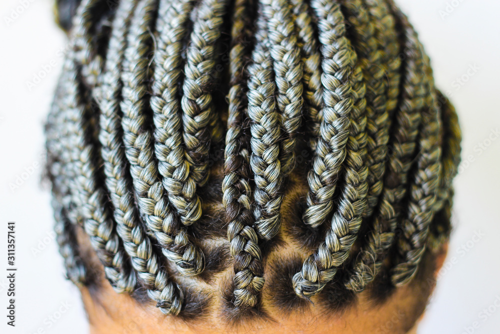 Young afro with blonde Box braids, African hair style also known as  "Kanekalon braids." Close up on decoration and style. Photos | Adobe Stock
