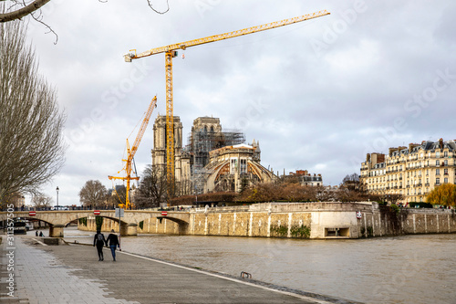 Paris, France - December 22, 2019: View of cranes and scaffoldings on the Notre Dame de Paris cathedral on the Ile de la Cite in the center of Paris after it was damaged by a fire in April 2019