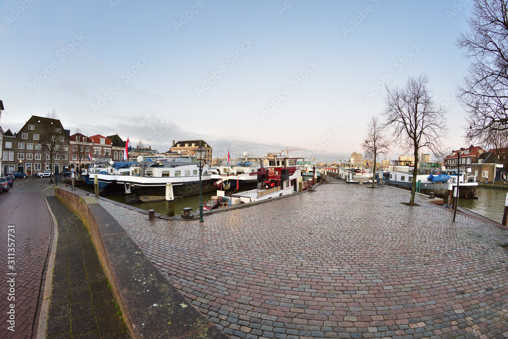 Fototapeta premium Marina i zacumowane jachty wśród domów mieszkalnych o wschodzie słońca.