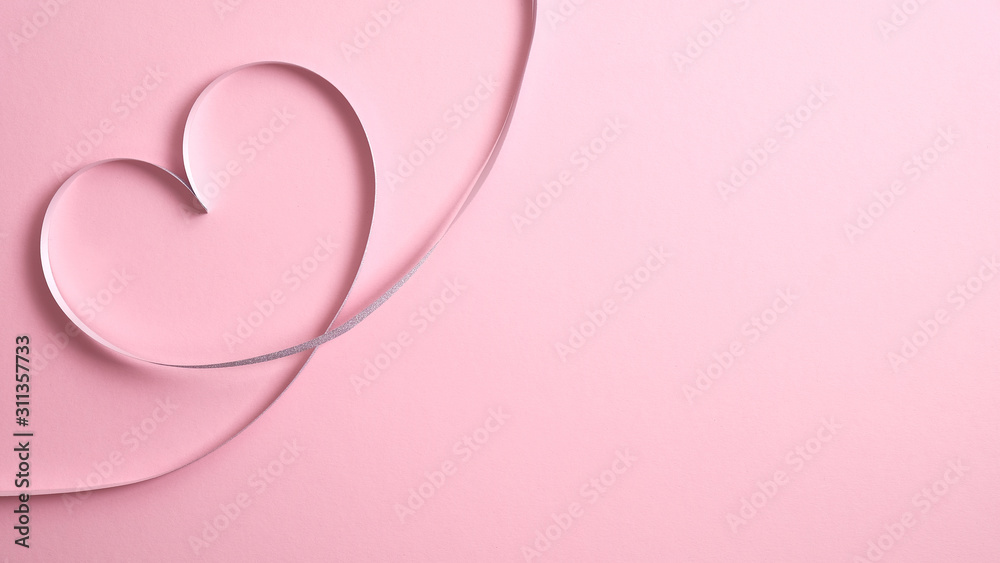 Heart shape border made of silver ribbon on pink background. Valentine's day greeting card mockup, minimal flat lay style composition with copy space. Love concept.