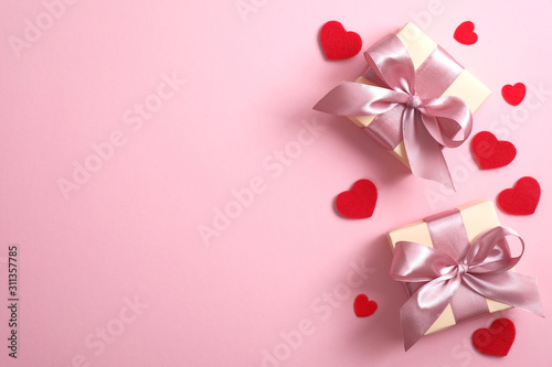 Gift boxes with pink ribbon and red hearts on pink background. Flat lay, top view, copy space. Valentine's day, anniversary, mother's day and birthday greeting card mockup.