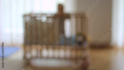 Very lonely one small boy, child in a baby cot. Out of focus. Alone. Sad. Lost.