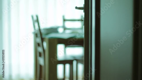 Doors open, close to an apartment with table. Out of focus. Mystery.