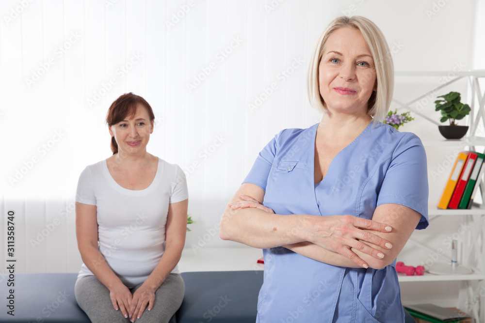 Physiotherapist smiling at camera in medical office