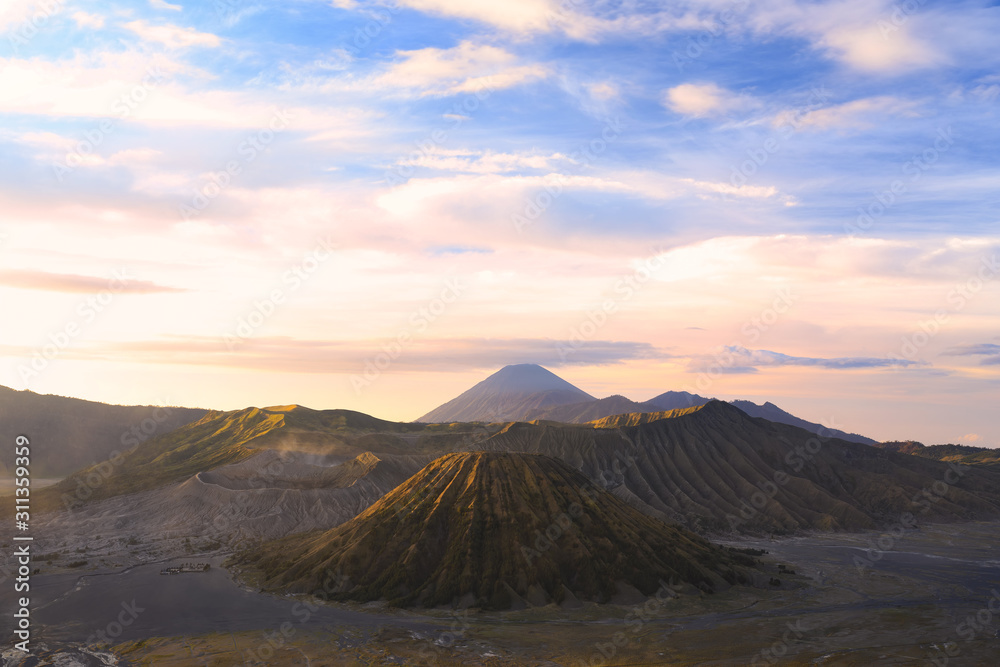 View from above, stunning aerial view of the Mount Batok, Mount Bromo and the Mount Semeru in the distance during a beautiful sunrise. Mount Bromo is an active volcano in East Java, Indonesia.