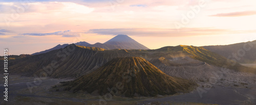 View from above, stunning aerial view of the Mount Batok, Mount Bromo and the Mount Semeru in the distance during a beautiful sunrise. Mount Bromo is an active volcano in East Java, Indonesia. © Travel Wild