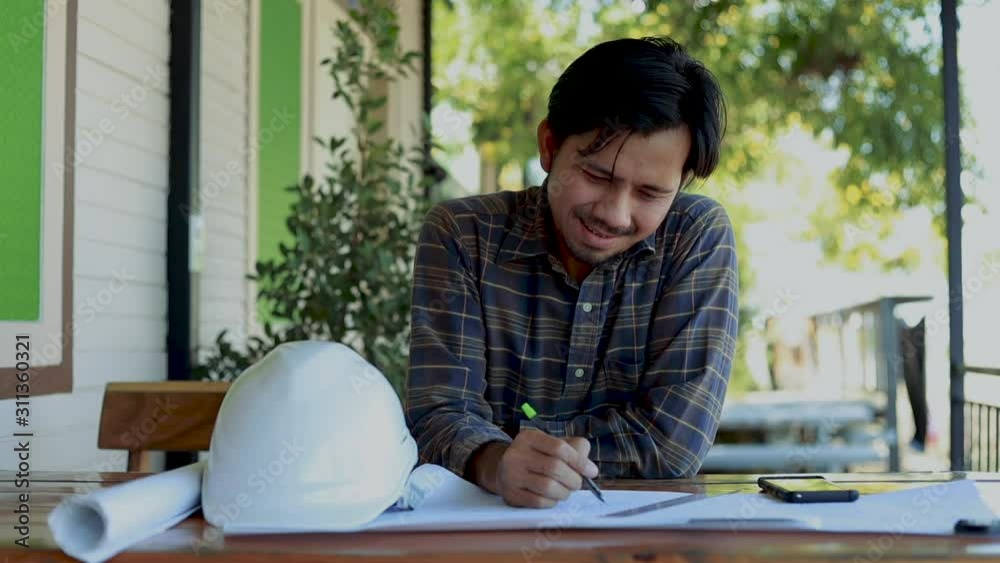 Civil male engineer asian thinking of work on blueprint architectural project and success Civil male engineer asian thinking of work on blueprint architectural project and success