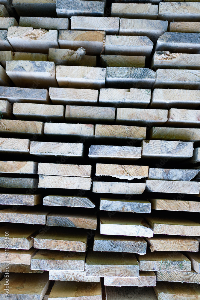 Pile of boards in a warehouse. Stacked wooden beams of rectangular section Pile of boards in a warehouse. Stacked wooden beams of rectangular section