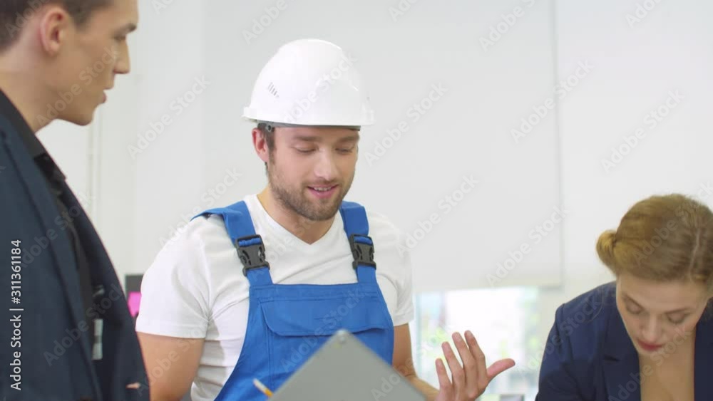 Builder in uniform emotionally discuss project of houses with engineers Builder in uniform emotionally discuss project of houses with engineers