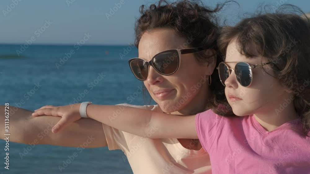 Women and girl with open hands at the sea.