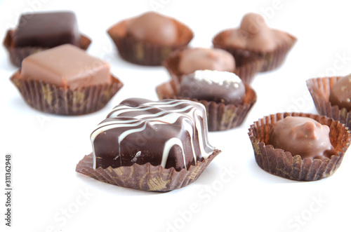 chocolate candies in a candy wrapper on a white background. A set of sweets with different tastes ..