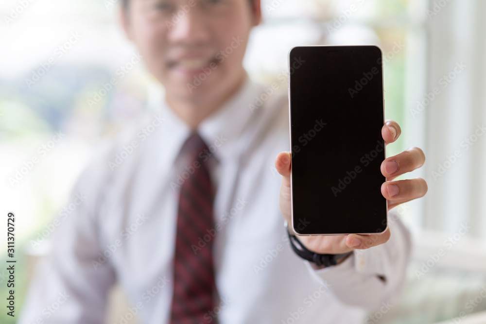 Mock up. Businessman showing a mobile phone with a black screen. Mock up. Businessman showing a mobile phone with a black screen.