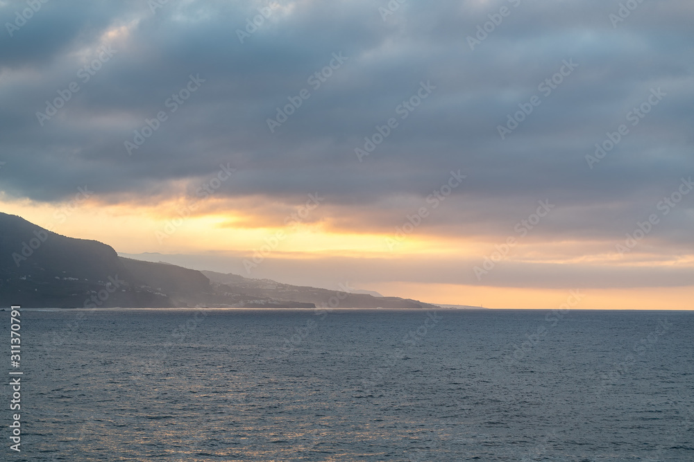 A cloudy sunset over the Atlantic Ocean in Puerto de la Cruz, Tenerife, Spain
