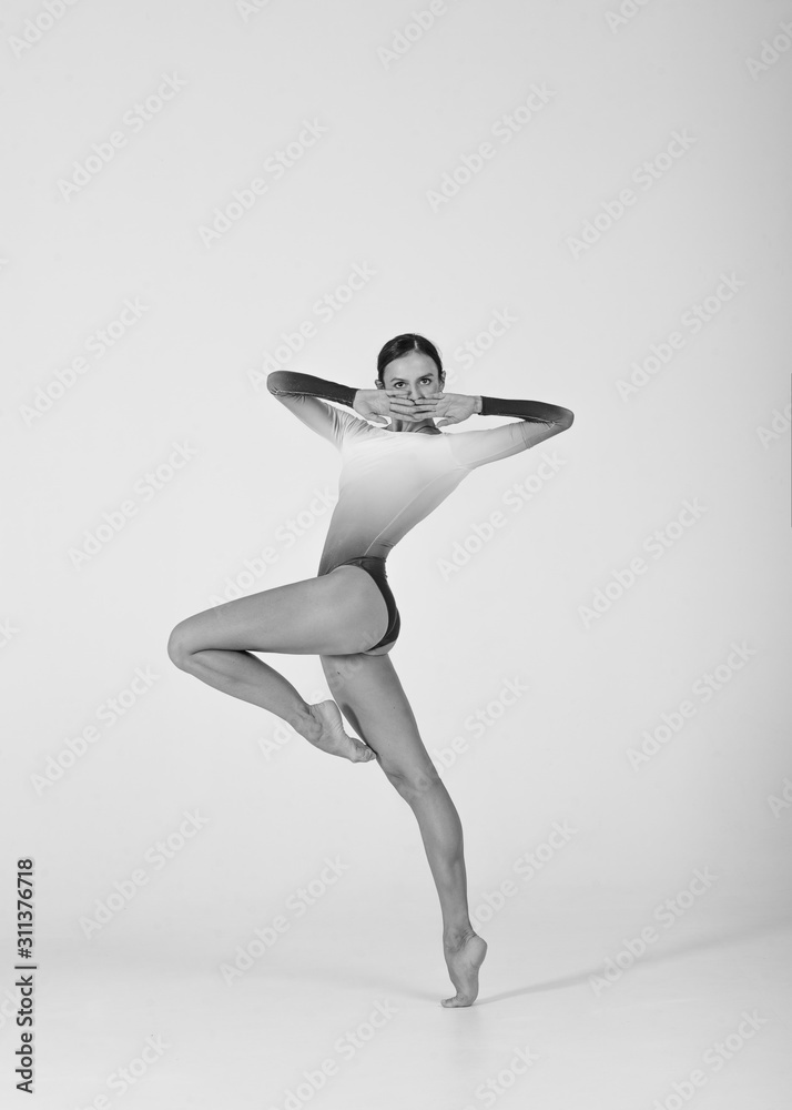 Girl dancer posing on a white background in a photo studio. Professional ballet dancer. Black and white photos. Girl dancer posing on a white background in a photo studio. Professional ballet dancer. Black and white photos.