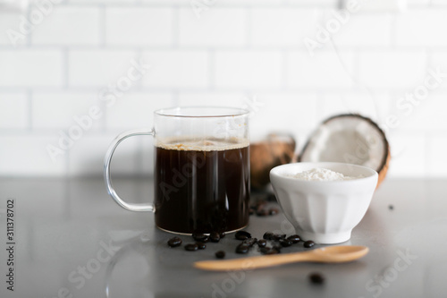 Cup of coffee with keto coconut creamer in white modern kitchen 