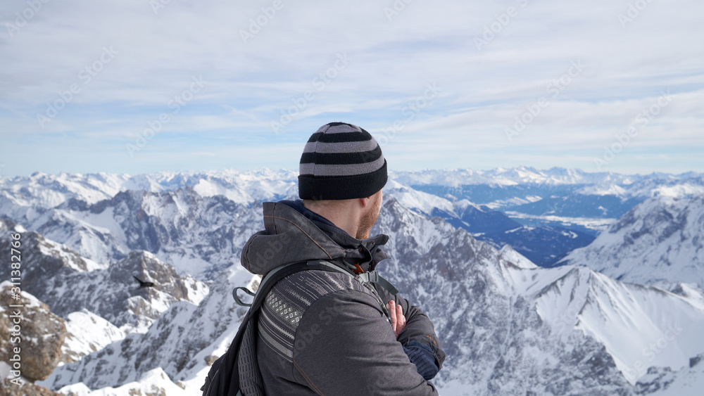 Traveler on the top of Zugspitze mountain, Germany. It is the highest peak of Wetterstein mountains in Germany.  It lies south of the town of Garmisch-Partenkirchen. Alps.