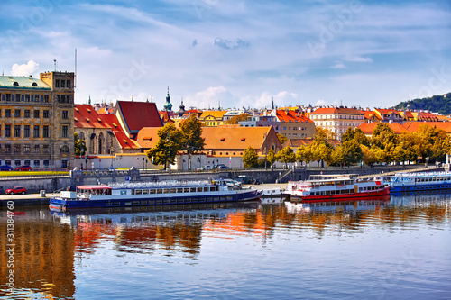 Scenic autumn sunset view of the Old Town pier architecture over Vltava river in Prague, Czech Republic