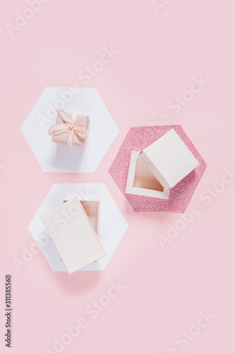 Festive pink flat lay. Set of gift boxes on white hexagons hexagons on a pink background, birthday, wedding day, mother's day, valentines day, greeting card